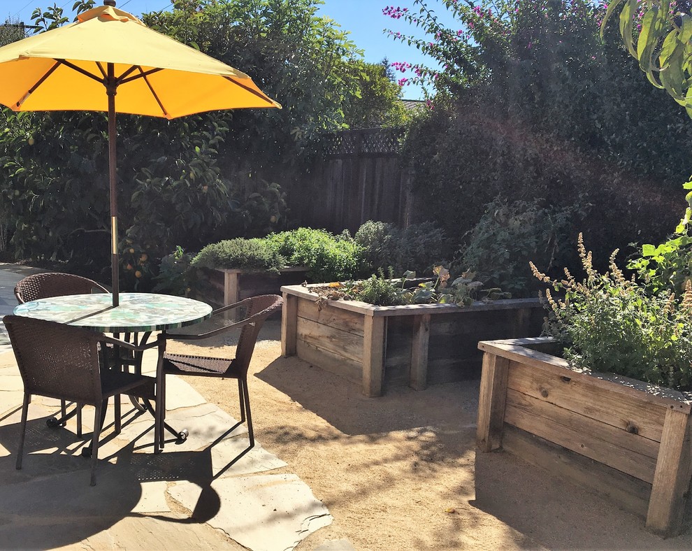 This is an example of a small contemporary backyard xeriscape in San Francisco with a vegetable garden and natural stone pavers.