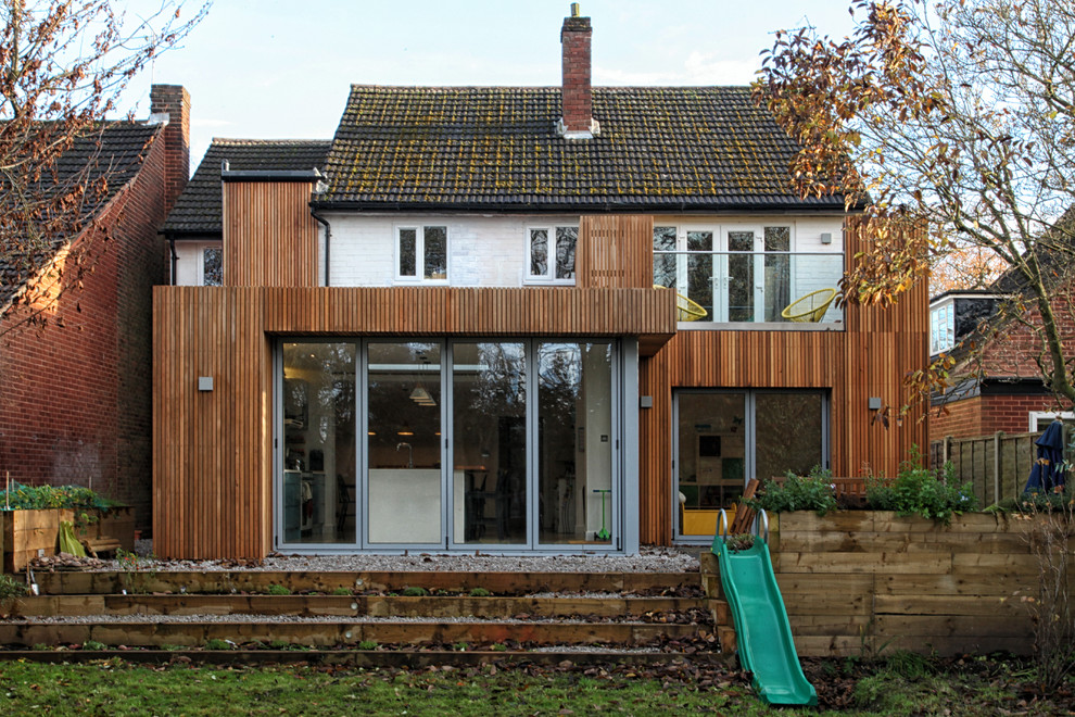 Inspiration for a mid-sized transitional two-storey brown house exterior in West Midlands with wood siding, a mixed roof and a gable roof.