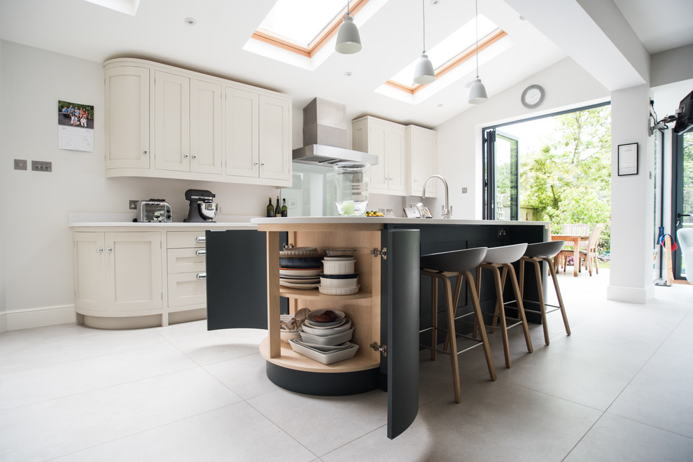 Expansive contemporary eat-in kitchen in London with a double-bowl sink, quartz benchtops, white splashback, stainless steel appliances, ceramic floors and with island.