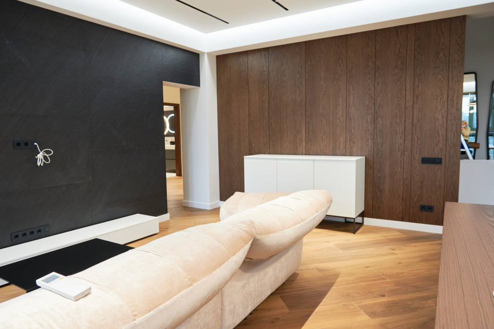 This is an example of a medium sized contemporary living room feature wall in Moscow with a home bar, black walls, laminate floors, no fireplace, a wall mounted tv, brown floors, a drop ceiling and wallpapered walls.