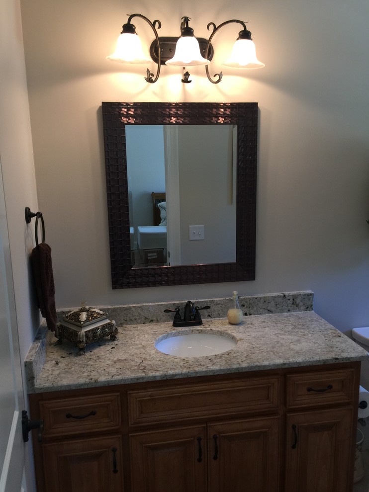 Mid-sized traditional 3/4 bathroom in Raleigh with recessed-panel cabinets, medium wood cabinets, laminate benchtops, a drop-in tub, a shower/bathtub combo, a two-piece toilet, beige tile, ceramic tile, beige walls, an undermount sink and a shower curtain.