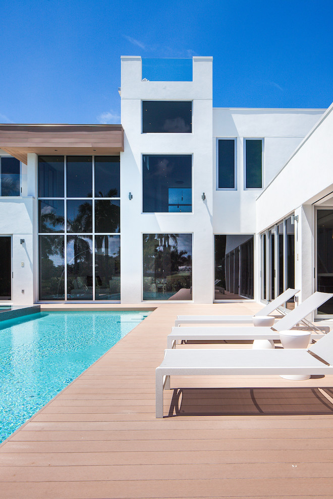 Design ideas for a contemporary backyard rectangular pool in Miami with decking.