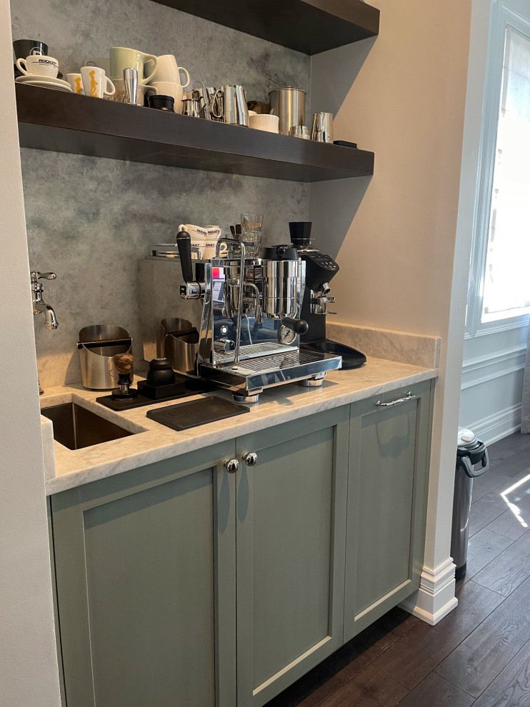 Inspiration for a small transitional u-shaped home bar in Chicago with an undermount sink, recessed-panel cabinets, green cabinets, quartzite benchtops, grey splashback, marble splashback, dark hardwood floors, brown floor and white benchtop.