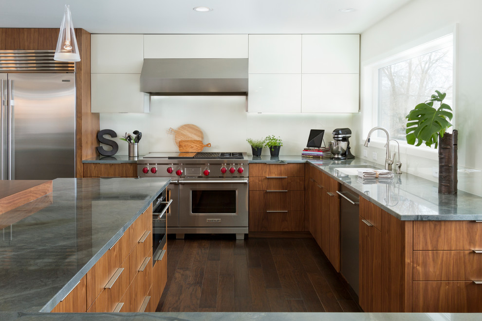 Large contemporary l-shaped eat-in kitchen in Minneapolis with an undermount sink, flat-panel cabinets, medium wood cabinets, granite benchtops, white splashback, glass sheet splashback, stainless steel appliances, dark hardwood floors and with island.