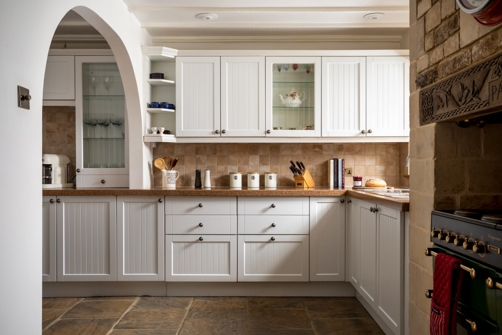 Design ideas for a mid-sized country l-shaped separate kitchen in Gloucestershire with a drop-in sink, shaker cabinets, white cabinets, granite benchtops, limestone floors and exposed beam.