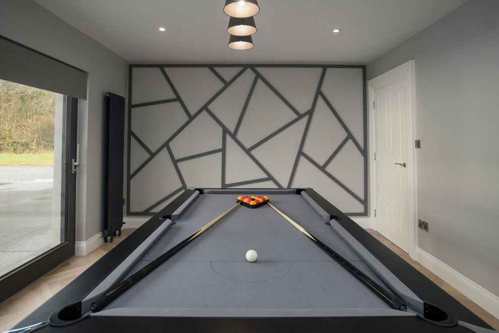 This is an example of a mid-sized contemporary enclosed family room in Dublin with a game room, grey walls, medium hardwood floors and grey floor.