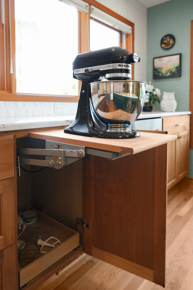Example of a transitional l-shaped medium tone wood floor kitchen design with shaker cabinets, white backsplash, an island and white countertops