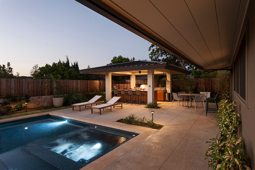 Photo of a large midcentury backyard rectangular aboveground pool in Hawaii with natural stone pavers.