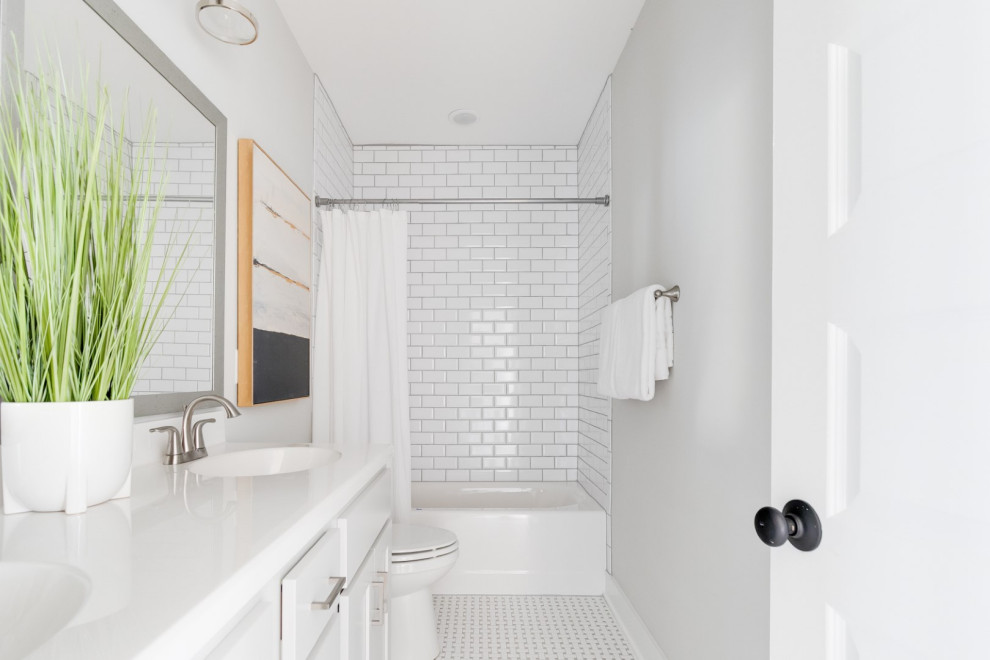 На фото: детская ванная комната среднего размера в классическом стиле с фасадами с утопленной филенкой, белыми фасадами, ванной в нише, душем над ванной, раздельным унитазом, белой плиткой, керамической плиткой, серыми стенами, паркетным полом среднего тона, монолитной раковиной, столешницей из искусственного камня, коричневым полом, шторкой для ванной, белой столешницей, тумбой под две раковины и встроенной тумбой с