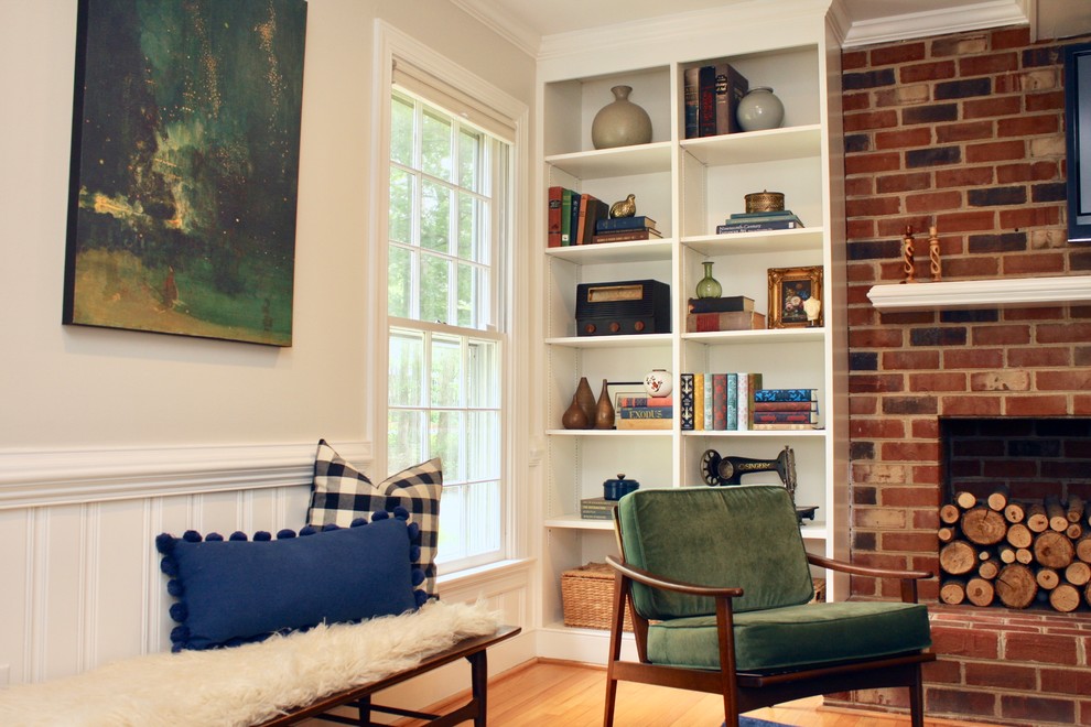 Mid-sized eclectic enclosed family room in Richmond with white walls, medium hardwood floors, a standard fireplace, a brick fireplace surround, a wall-mounted tv and yellow floor.