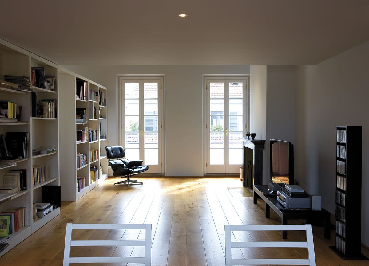 Esempio di un ampio soggiorno moderno stile loft con parquet chiaro, camino classico, cornice del camino in pietra e TV autoportante