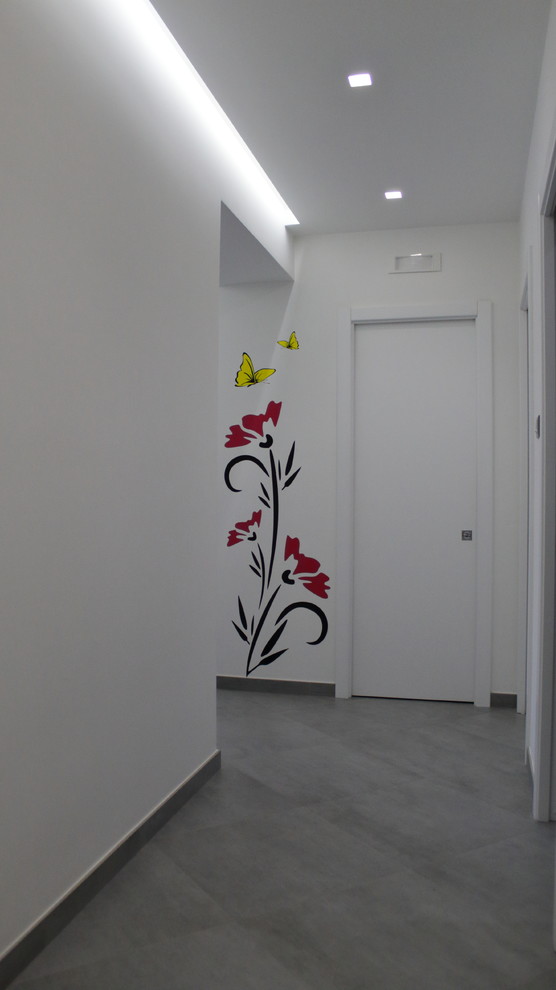 This is an example of a mid-sized contemporary hallway in Bari with white walls, porcelain floors and grey floor.