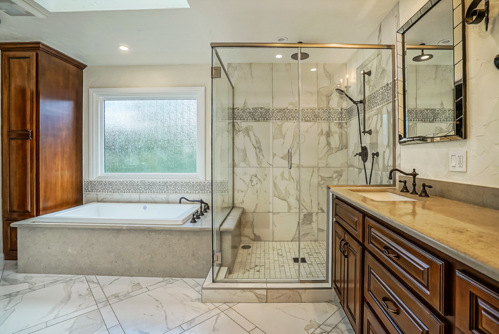Large traditional master bathroom in Los Angeles with raised-panel cabinets, dark wood cabinets, a drop-in tub, an alcove shower, a two-piece toilet, gray tile, white tile, porcelain tile, grey walls, porcelain floors, an undermount sink, concrete benchtops, white floor and a hinged shower door.