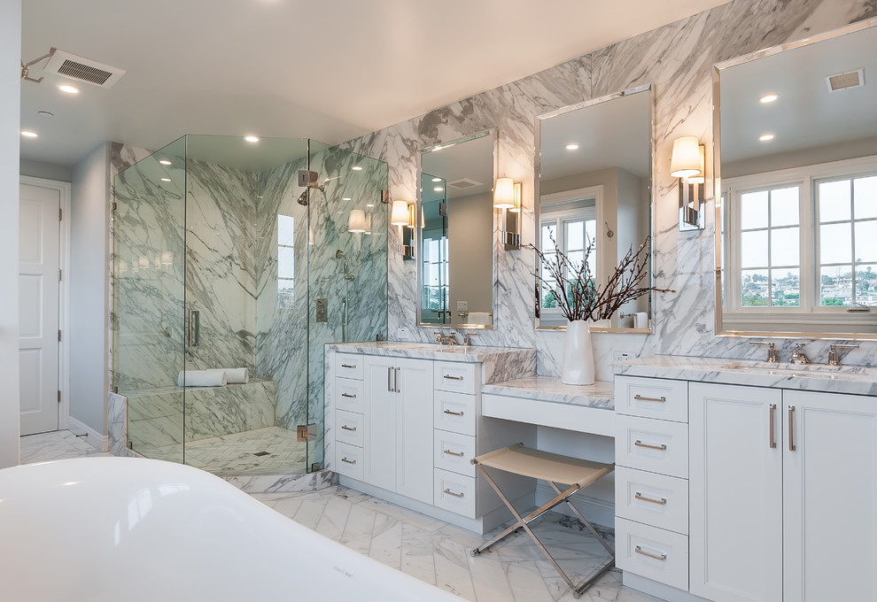 Inspiration for a transitional master bathroom in Los Angeles with recessed-panel cabinets, white cabinets, a freestanding tub, a corner shower, white tile, grey walls, an undermount sink, white floor, a hinged shower door, white benchtops and a shower seat.