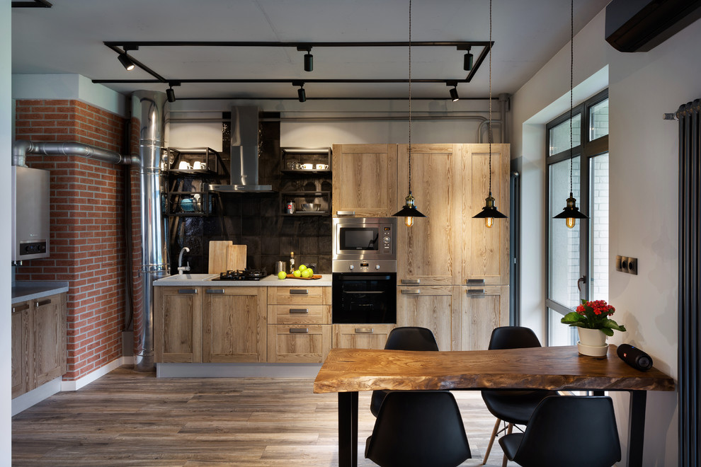 Design ideas for a mid-sized industrial single-wall eat-in kitchen in Moscow with laminate floors, brown floor, a drop-in sink, solid surface benchtops, black splashback, ceramic splashback, stainless steel appliances, no island, shaker cabinets and light wood cabinets.