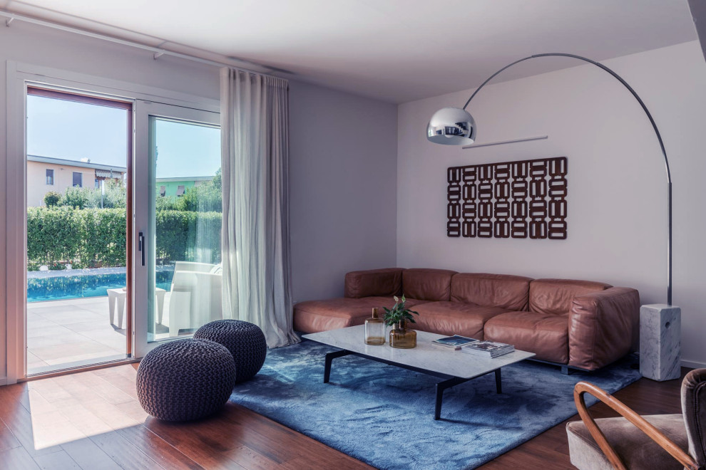 Immagine di un soggiorno contemporaneo di medie dimensioni e aperto con pareti beige, pavimento in legno verniciato, pavimento marrone e tappeto