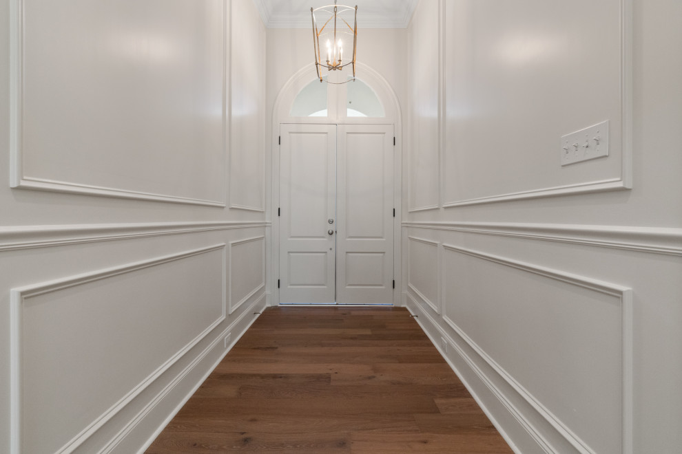 Design ideas for a large contemporary foyer in New Orleans with white walls, medium hardwood floors, a double front door and a white front door.