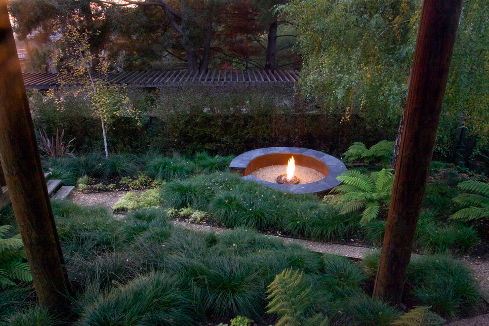 Inspiration for an industrial backyard garden in San Francisco with a fire feature and decomposed granite.