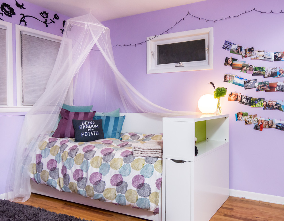 Ispirazione per una camera da letto minimalista di medie dimensioni con pareti viola, pavimento in legno massello medio e nessun camino