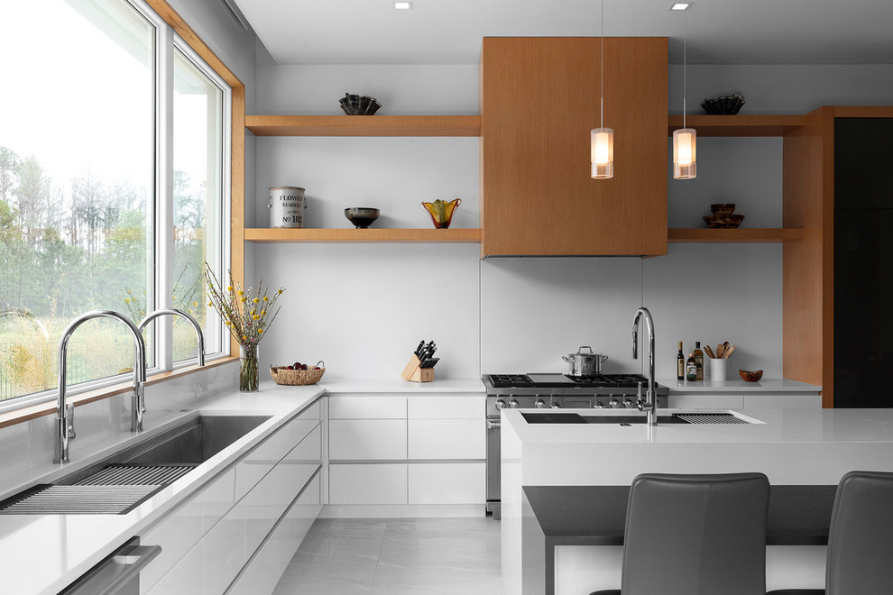 Inspiration for a large contemporary l-shaped kitchen in Orlando with white splashback, stainless steel appliances, with island, an undermount sink, flat-panel cabinets, white cabinets, grey floor and white benchtop.