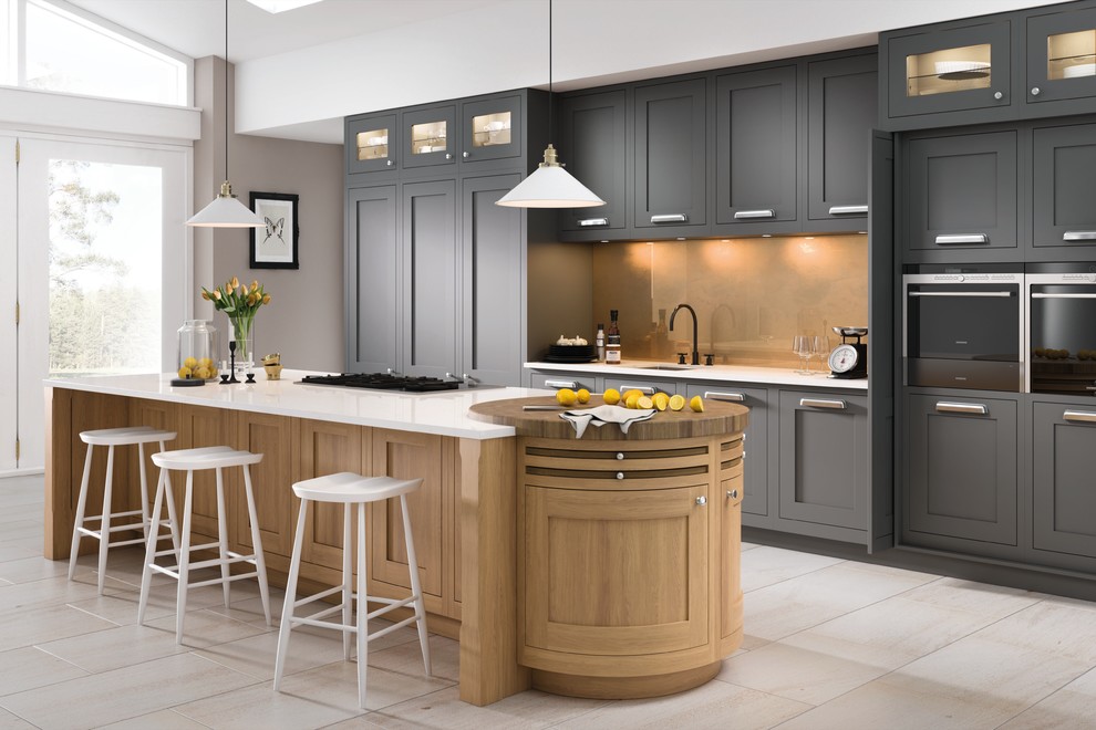 This is an example of a transitional galley kitchen in Other with an undermount sink, shaker cabinets, grey cabinets, beige splashback, glass sheet splashback, stainless steel appliances, with island, beige floor and white benchtop.