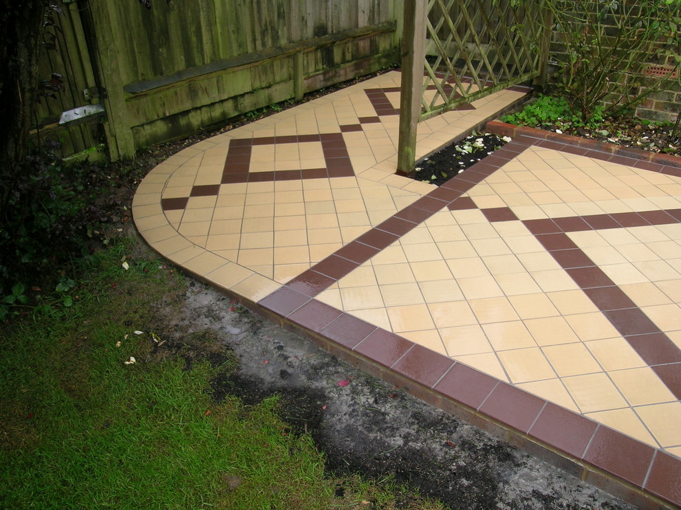 This is an example of a mid-sized traditional backyard patio in Other with tile.