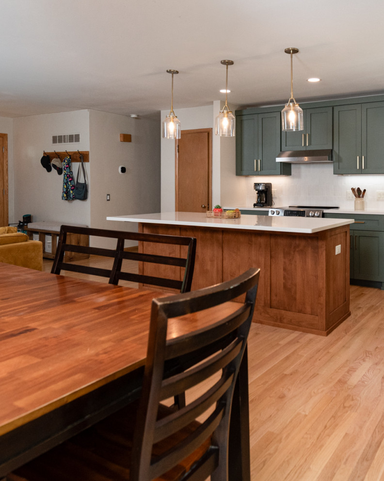 Transitional light wood floor kitchen photo with shaker cabinets, green cabinets, quartz countertops, white backsplash, ceramic backsplash and an island