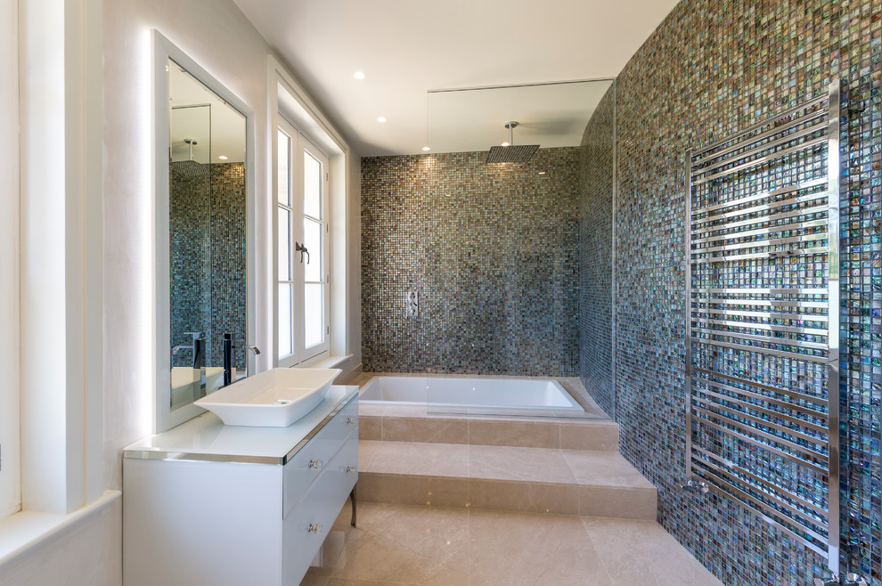 This is an example of a mid-sized traditional bathroom in Surrey with flat-panel cabinets, white cabinets, a japanese tub, a shower/bathtub combo, blue tile, mosaic tile, blue walls, a vessel sink, beige floor, an open shower and white benchtops.