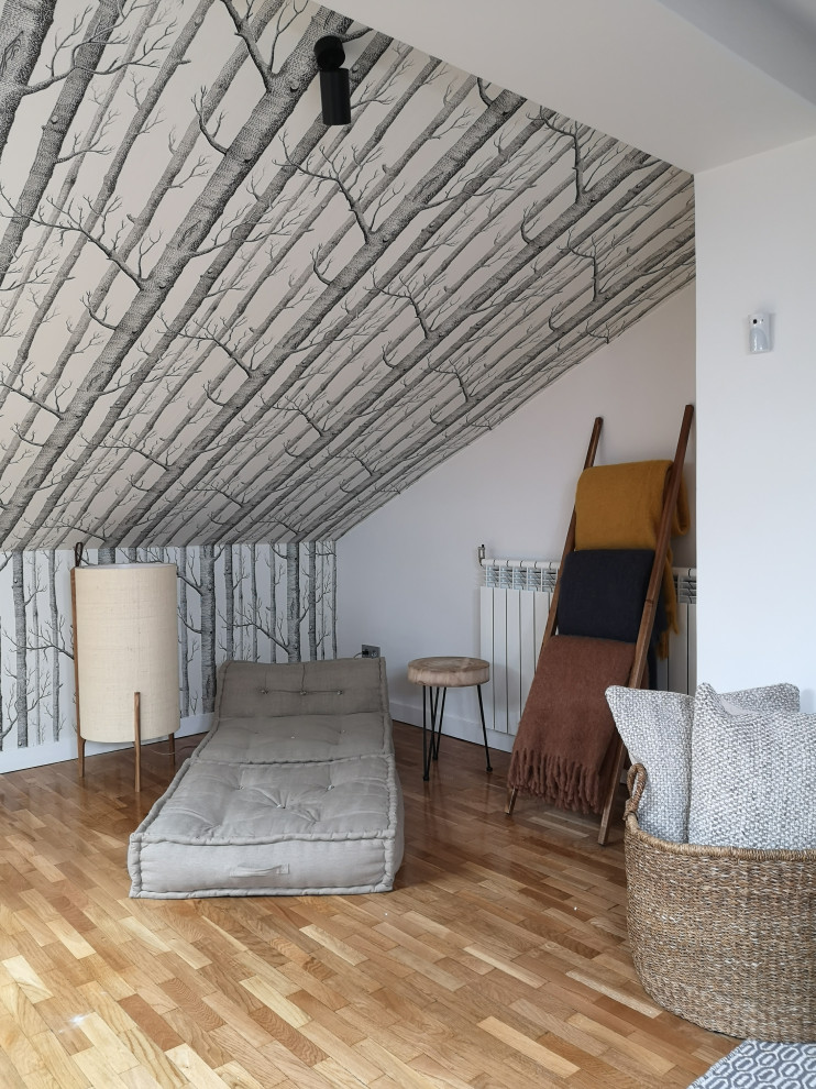 Пример оригинального дизайна: открытая гостиная комната в скандинавском стиле с с книжными шкафами и полками, светлым паркетным полом, потолком с обоями и ковром на полу без телевизора