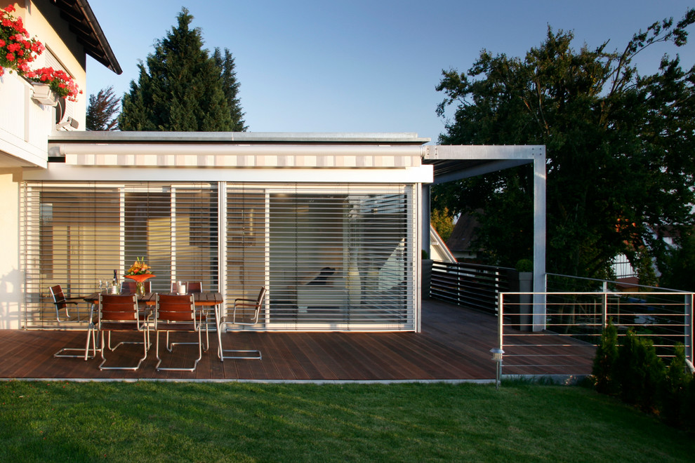 Inspiration for a large contemporary side yard deck in Stuttgart with an awning.
