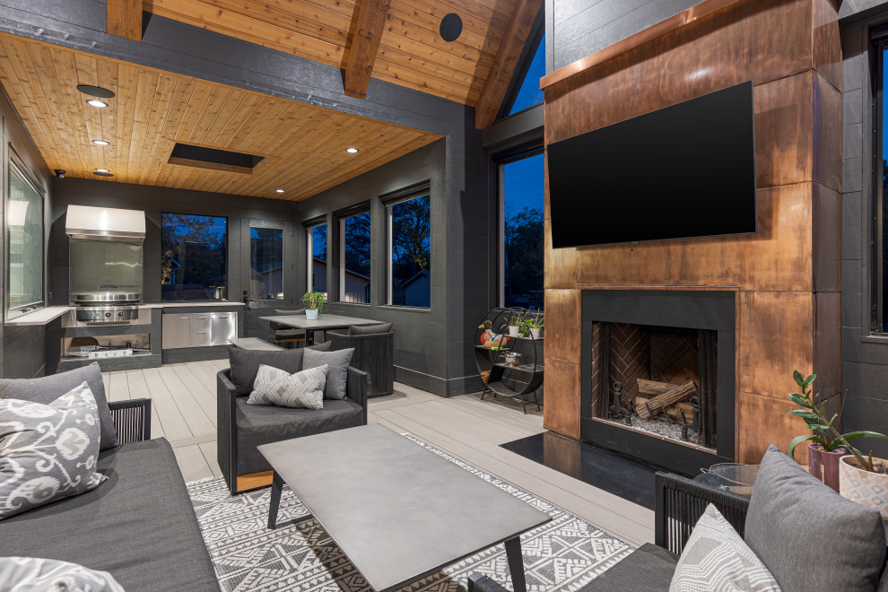 This is an example of a large modern sunroom in Chicago with a standard fireplace, a skylight and grey floor.