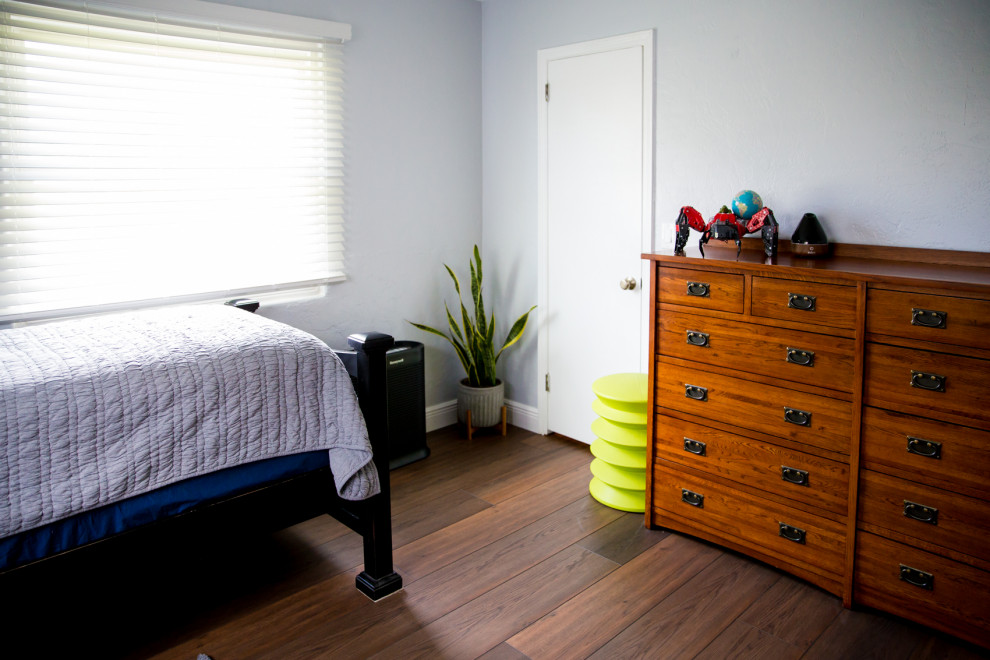 Example of a large trendy master vinyl floor and brown floor bedroom design in Other with blue walls