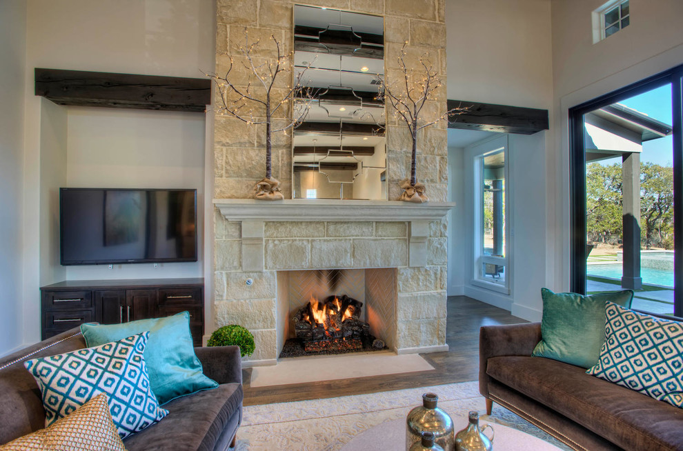 Design ideas for a mid-sized transitional formal enclosed living room in Austin with white walls, medium hardwood floors, a standard fireplace, a stone fireplace surround and a wall-mounted tv.