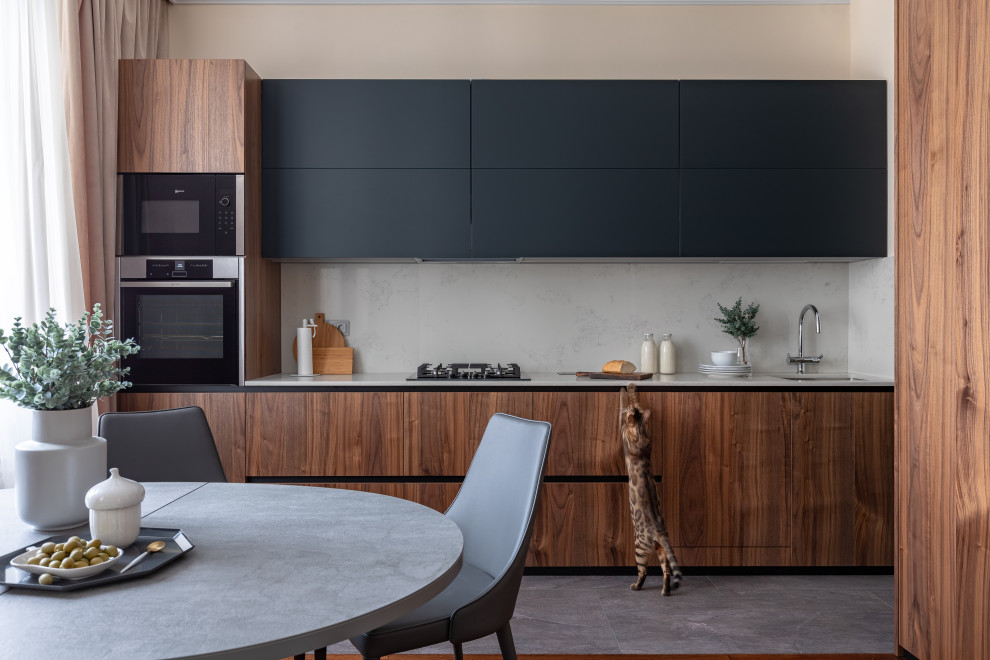 Design ideas for a mid-sized contemporary single-wall eat-in kitchen in Moscow with a single-bowl sink, black cabinets, quartz benchtops, white splashback, engineered quartz splashback, panelled appliances, no island and white benchtop.