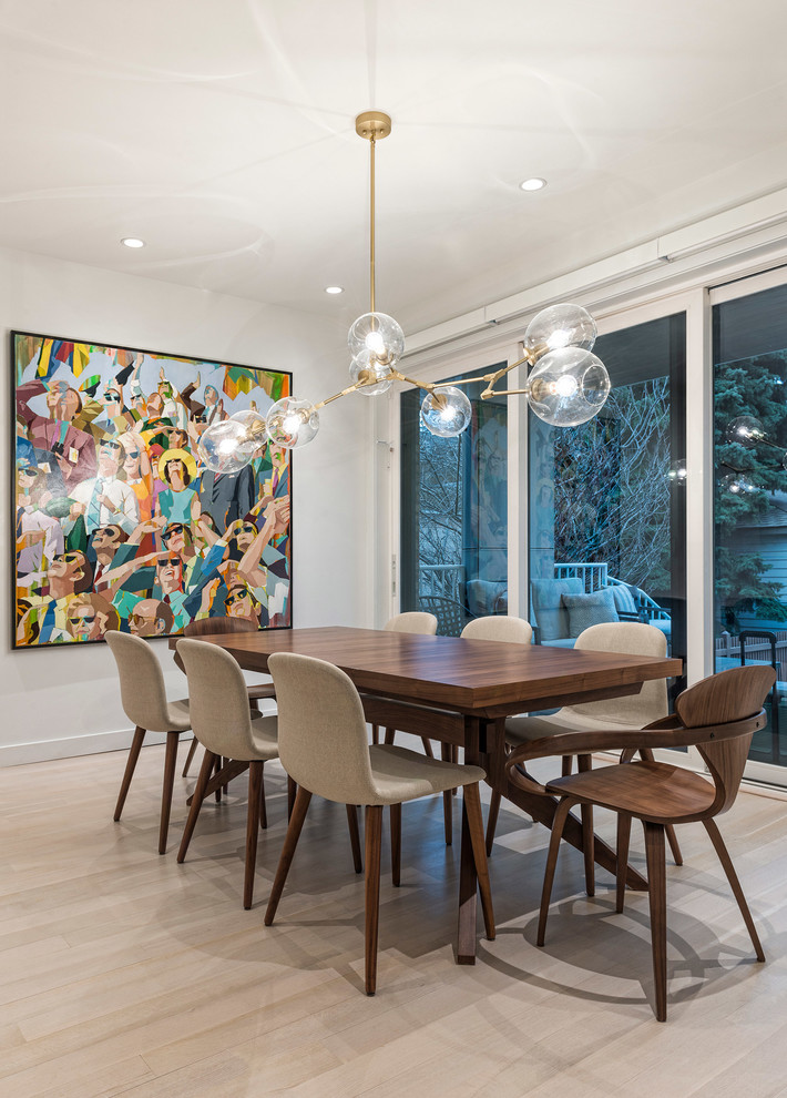 Example of a trendy light wood floor and beige floor dining room design in Chicago with white walls
