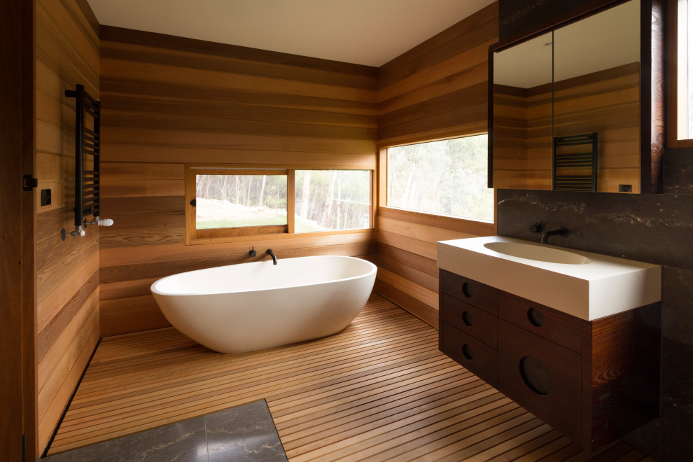 Ispirazione per una stanza da bagno nordica con ante in legno scuro, vasca freestanding, lavabo integrato, top in superficie solida, top bianco, un lavabo e mobile bagno sospeso