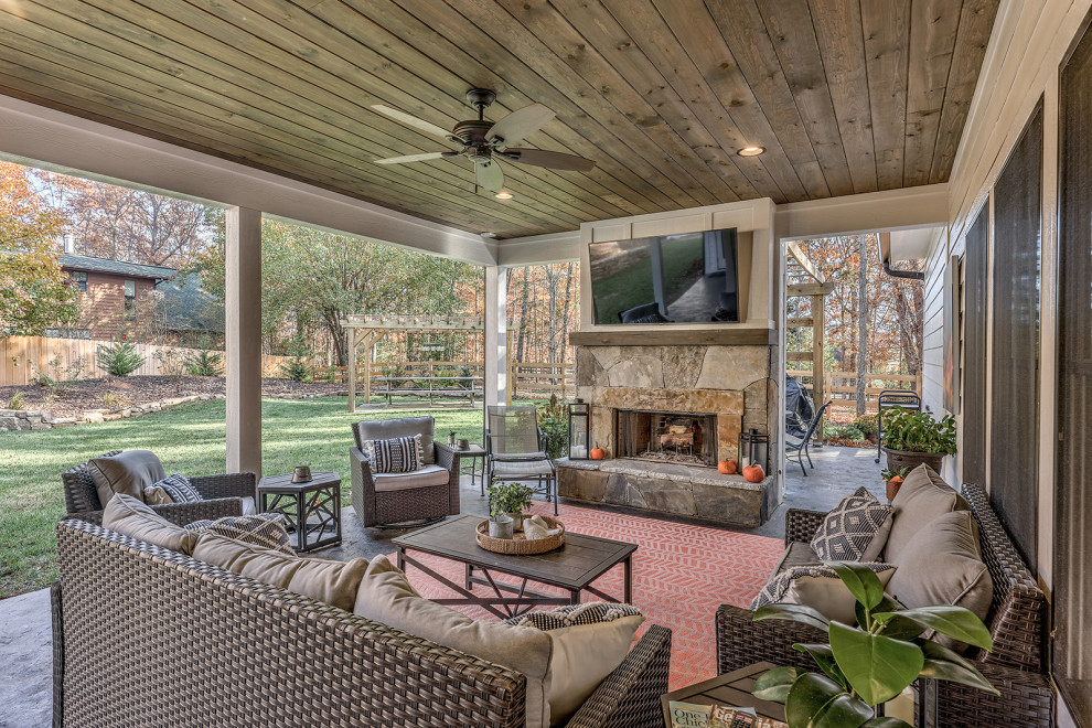 Photo of a large country backyard patio in Atlanta with with fireplace, stamped concrete and a roof extension.
