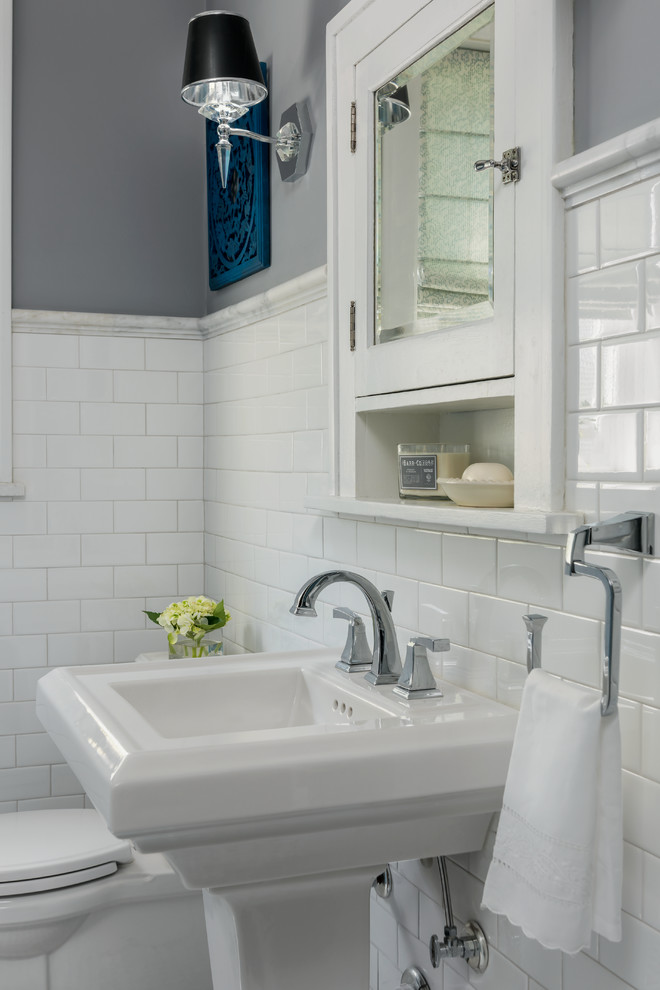 Design ideas for a small traditional bathroom in St Louis with glass-front cabinets, blue cabinets, a curbless shower, a two-piece toilet, white tile, ceramic tile, grey walls, marble floors, a pedestal sink, grey floor and a sliding shower screen.