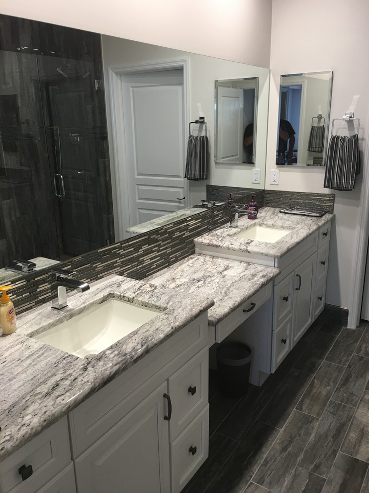 Inspiration for a mid-sized modern master bathroom in Newark with raised-panel cabinets, white cabinets, a one-piece toilet, white walls, an undermount sink, marble benchtops, an alcove shower, gray tile, plywood floors and ceramic tile.