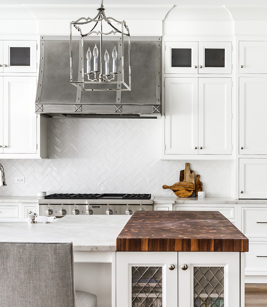 Kitchen - large transitional dark wood floor kitchen idea in Chicago with a farmhouse sink, recessed-panel cabinets, white cabinets, white backsplash, subway tile backsplash, stainless steel appliances and an island