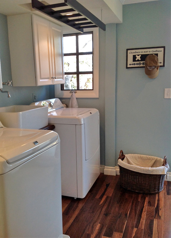 Photo of a small beach style laundry room in San Diego with a farmhouse sink, wood benchtops and a side-by-side washer and dryer.