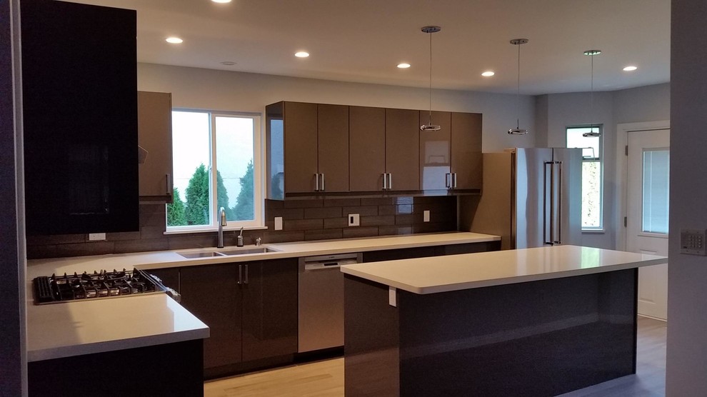 Example of a mid-sized transitional l-shaped light wood floor and beige floor enclosed kitchen design in Vancouver with an undermount sink, flat-panel cabinets, gray cabinets, quartz countertops, gray backsplash, glass tile backsplash, stainless steel appliances and an island