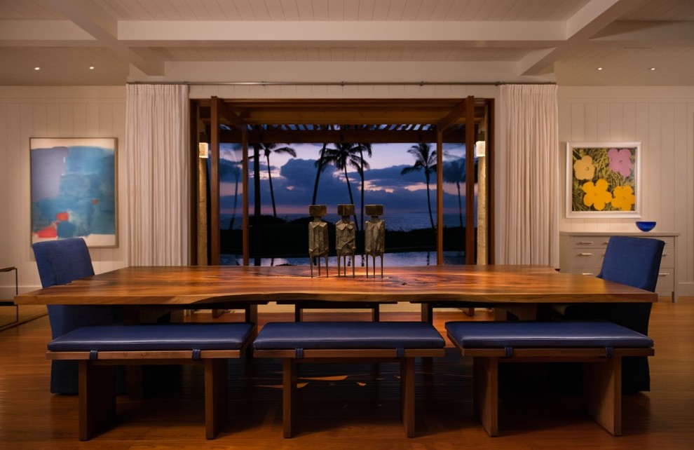 Example of a large island style medium tone wood floor and brown floor great room design in Hawaii with white walls and no fireplace