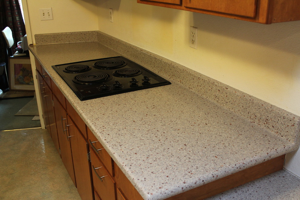 Inspiration for a contemporary kitchen remodel with solid surface countertops and black appliances