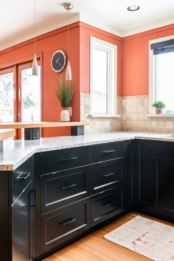 Inspiration for a mid-sized transitional u-shaped medium tone wood floor and brown floor eat-in kitchen remodel with an undermount sink, shaker cabinets, distressed cabinets, quartz countertops, white backsplash, travertine backsplash, stainless steel appliances, a peninsula and multicolored countertops