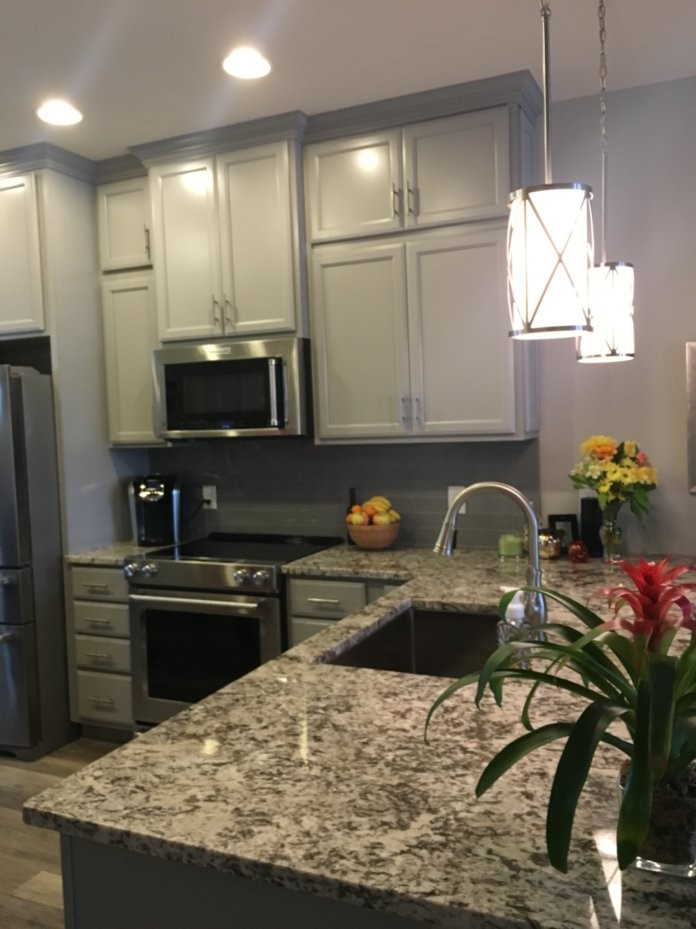 Inspiration for a mid-sized transitional l-shaped vinyl floor and brown floor eat-in kitchen remodel in Wilmington with an undermount sink, gray backsplash, glass tile backsplash and stainless steel appliances