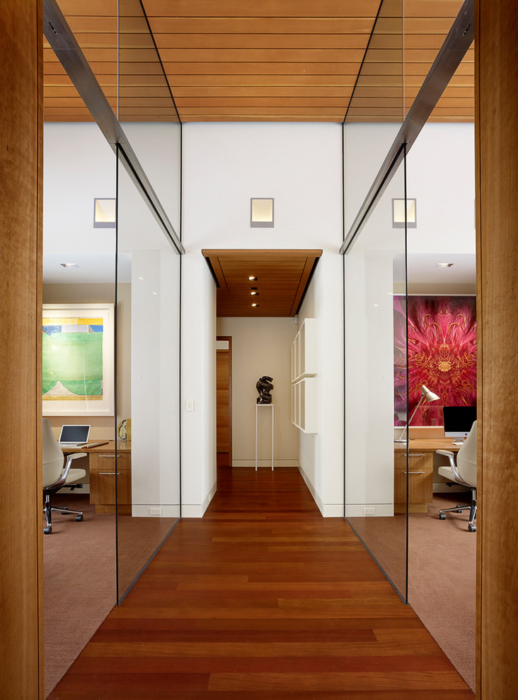 This is an example of a contemporary hallway in Other with white walls and medium hardwood floors.