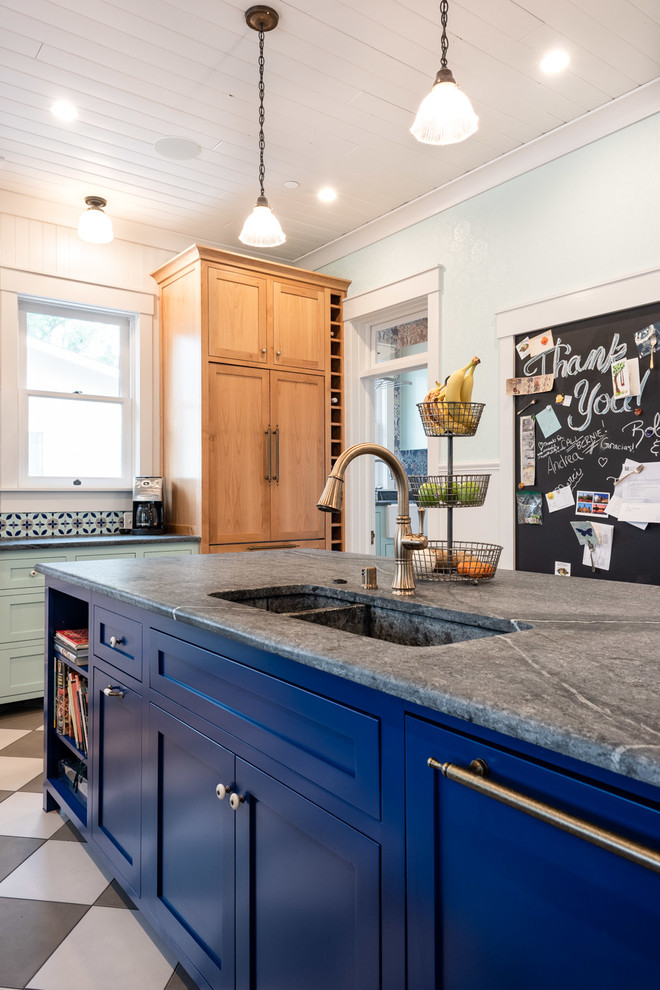 Photo of a large eclectic u-shaped eat-in kitchen in San Luis Obispo with a double-bowl sink, shaker cabinets, blue cabinets, multi-coloured splashback, brick splashback, porcelain floors, multiple islands, multi-coloured floor and grey benchtop.