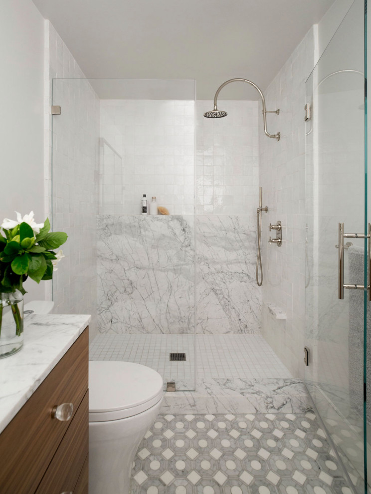 Пример оригинального дизайна: главная ванная комната среднего размера в современном стиле с плоскими фасадами, фасадами цвета дерева среднего тона, открытым душем, раздельным унитазом, белой плиткой, терракотовой плиткой, белыми стенами, полом из мозаичной плитки, врезной раковиной, мраморной столешницей, серым полом, душем с распашными дверями, белой столешницей, тумбой под одну раковину и напольной тумбой