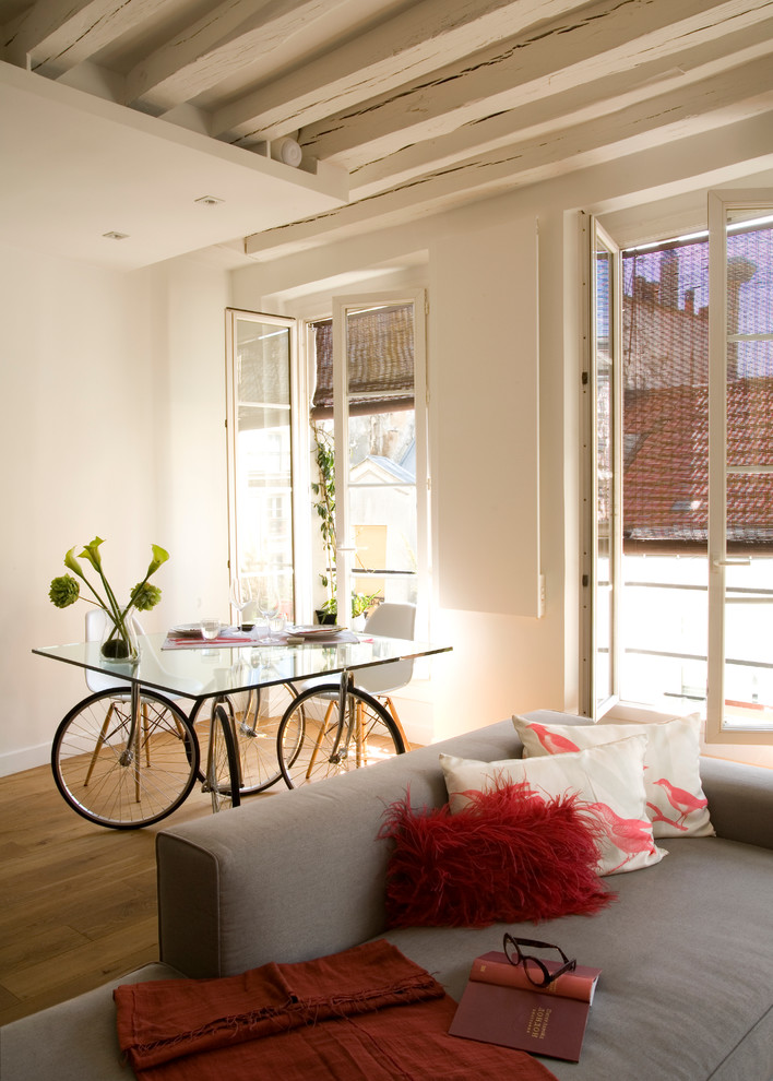 Inspiration pour une salle à manger ouverte sur le salon design de taille moyenne avec un mur blanc et un sol en bois brun.
